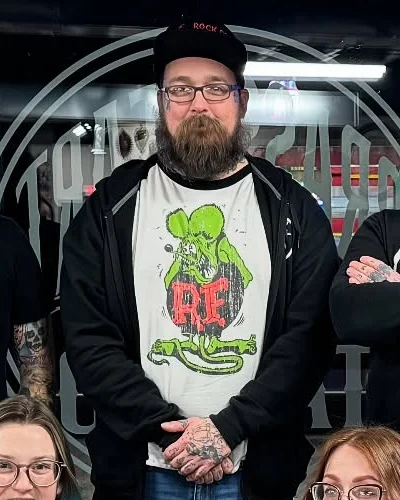 Mike Geiger in a black cap and a Rat Fink shirt